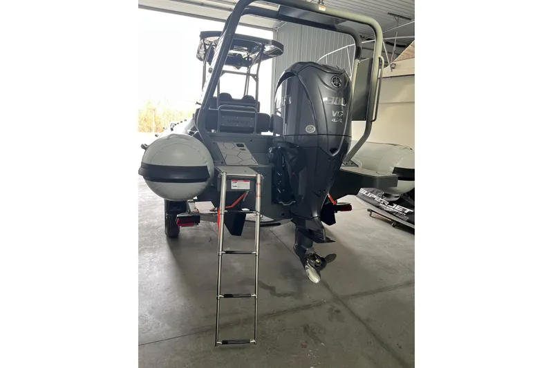 Slide: The Image of Highfield Sport 760 boat, 2026 model, featuring a powerful outboard motor and ladder in a garage setting. - 3