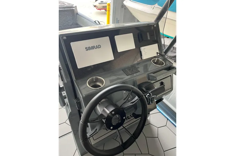 Slide: The Image of 2026 Highfield Sport 760 boat dashboard with Simrad navigation system and steering wheel. - 8