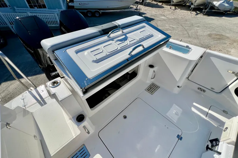 Slide: The Image of 2026 Robalo R300 Center Console boat with open storage compartment and dual engines. - 13