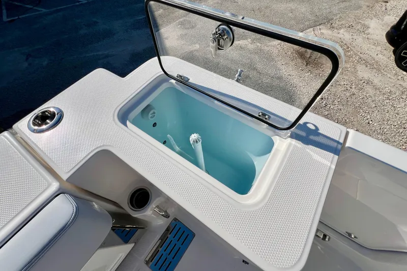 Slide: The Image of 2026 Robalo R300 Center Console livewell with open lid, showcasing interior design. - 17