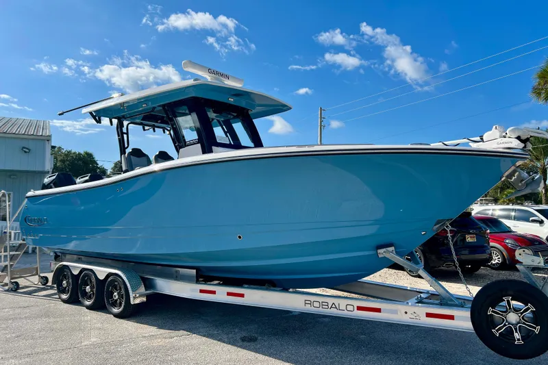 Slide: The Image of 2026 Robalo R300 Center Console boat on trailer under clear blue sky. - 26
