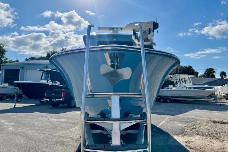 Slide: The Image of 2026 Robalo R300 Center Console boat with ladder, parked outdoors under a blue sky. - 28