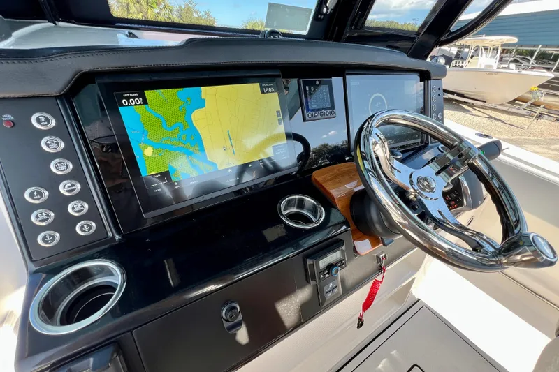 Slide: The Image of 2026 Robalo R300 Center Console boat dashboard with navigation display and steering wheel. - 31