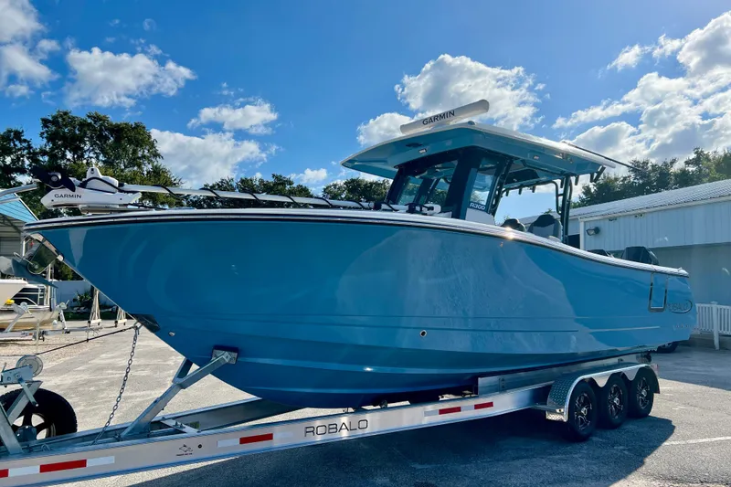 Slide: The Image of 2026 Robalo R300 Center Console boat on trailer under blue sky. - 5