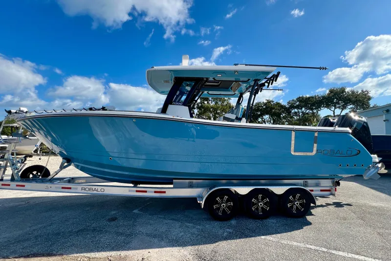 Slide: The Image of 2026 Robalo R300 Center Console boat on trailer under blue sky. - 6