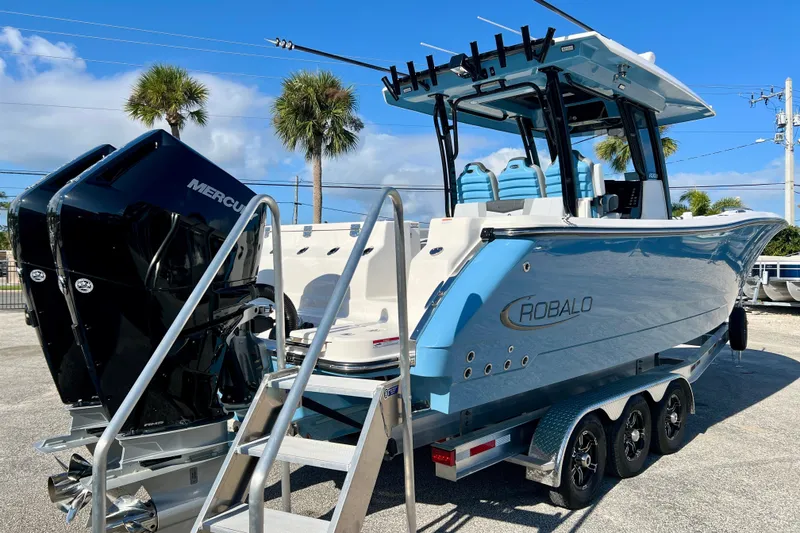 Slide: The Image of 2026 Robalo R300 Center Console boat with dual Mercury engines on a trailer. - 9