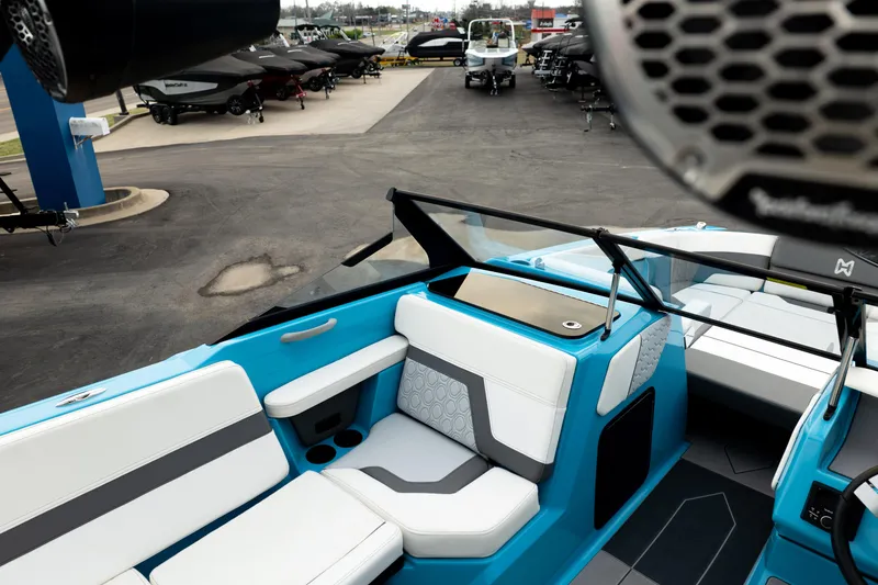 Slide: The Image of 2023 Heyday H22 boat interior with blue and white seating, parked at a dealership. - 21