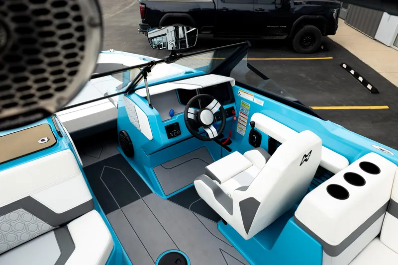 Slide: The Image of 2023 Heyday H22 boat interior with blue and white seating, steering wheel, and cup holders. - 22