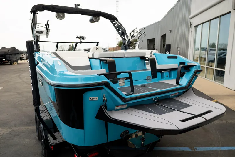 Slide: The Image of 2023 Heyday H22 boat with blue exterior, rear view, parked near a building. - 5