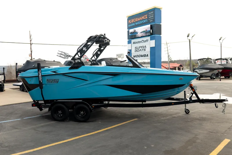 Slide: The Image of 2023 Heyday H22 boat in vibrant blue on trailer at a marine dealership. - 8