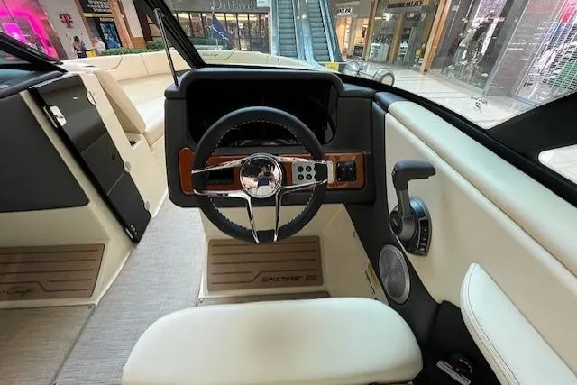 Slide: The Image of 2026 Chris-Craft Sportster 25 boat interior with steering wheel and dashboard in a showroom. - 12