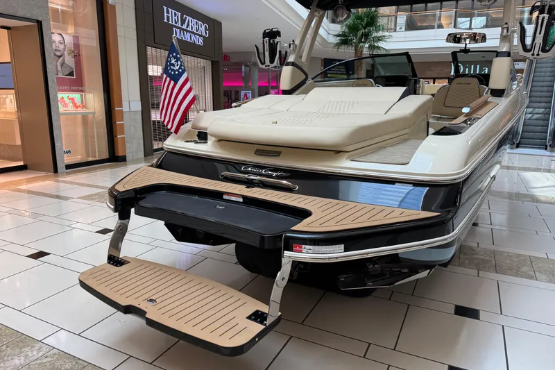 Slide: The Image of 2026 Chris-Craft Sportster 25 boat displayed in a shopping mall with American flag. - 22