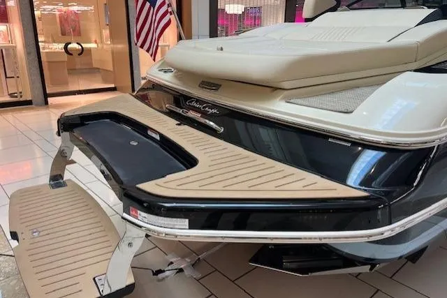Slide: The Image of 2026 Chris-Craft Sportster 25 boat displayed indoors with American flag in background. - 3