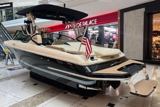 Slide: The Image of 2026 Chris-Craft Sportster 25 boat displayed indoors with American flag. - 6