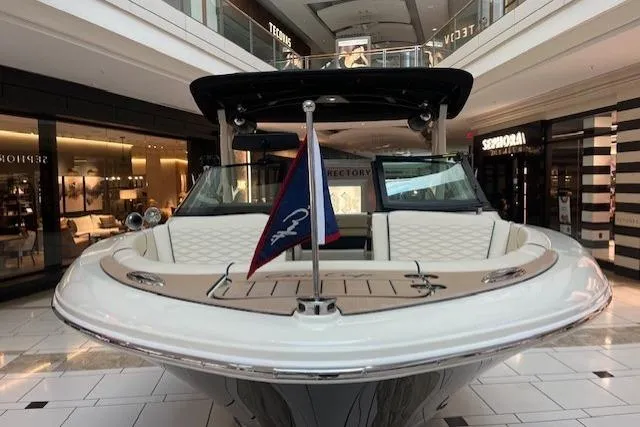 Slide: The Image of 2026 Chris-Craft Sportster 25 boat displayed indoors, showcasing sleek design and luxury features. - 7