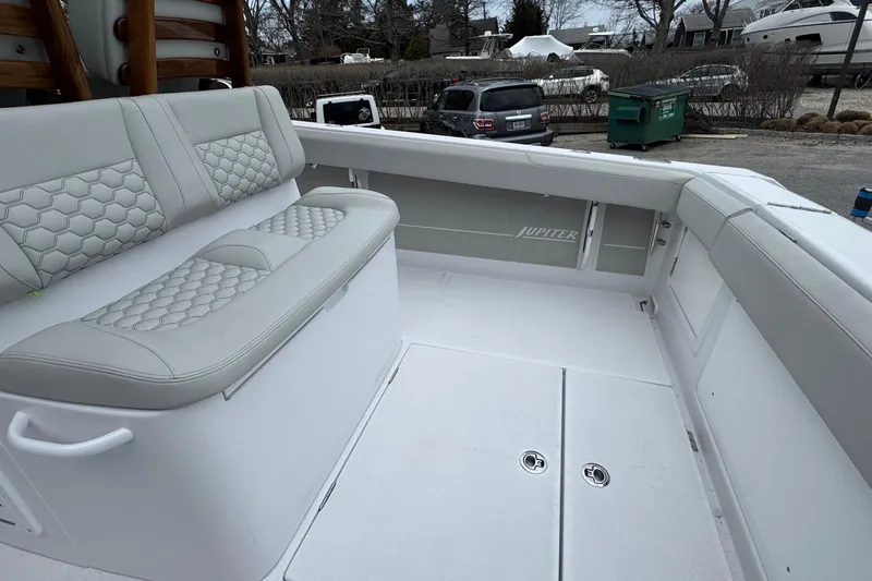 Slide: The Image of 2026 Jupiter 30 boat interior with cushioned seating and sleek design. - 19