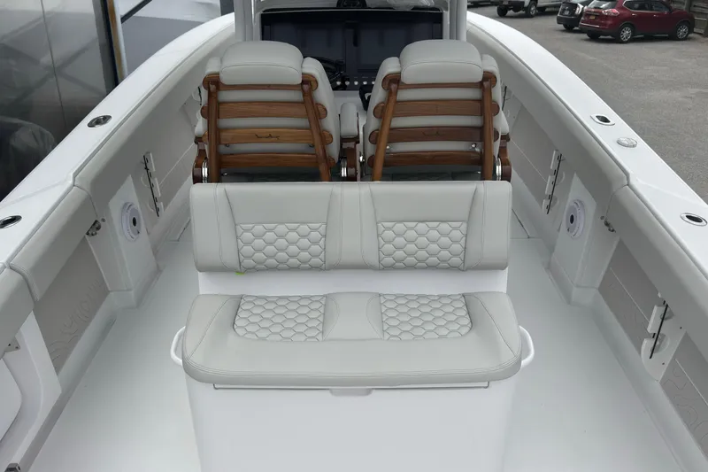 Slide: The Image of 2026 Jupiter 30 boat interior with white cushioned seating and wooden accents. - 30
