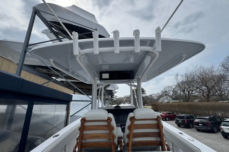 Slide: The Image of 2026 Jupiter 30 boat with sleek design, docked outdoors under cloudy sky. - 33