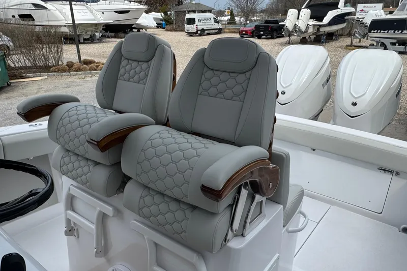 Slide: The Image of Luxury seating on a 2026 Jupiter 30 boat, featuring elegant gray upholstery and wooden armrests. - 39