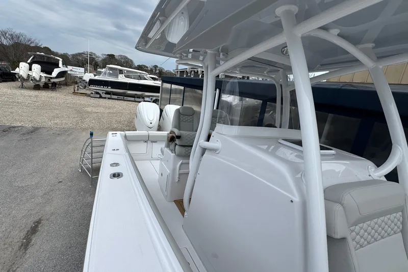 Slide: The Image of 2026 Jupiter 30 boat with sleek design, parked in a marina with other vessels. - 44