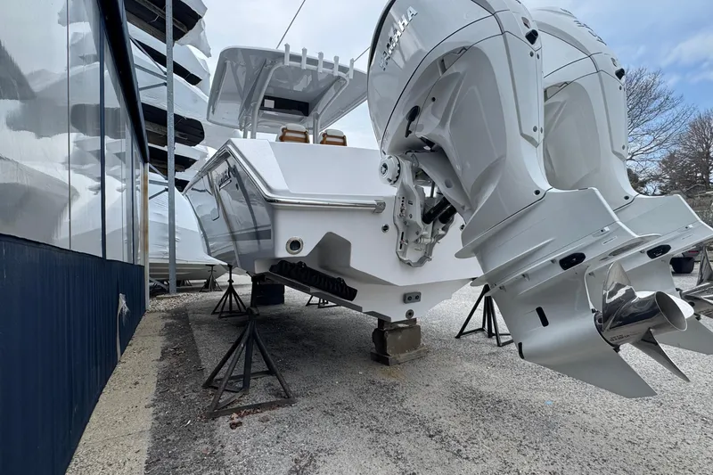 Slide: The Image of 2026 Jupiter 30 boat with dual outboard engines on stands, side view. - 5