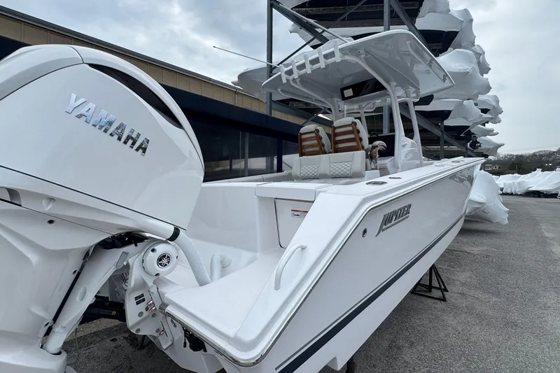 Slide: The Image of 2026 Jupiter 30 boat with Yamaha engine, docked outdoors under cloudy sky. - 9