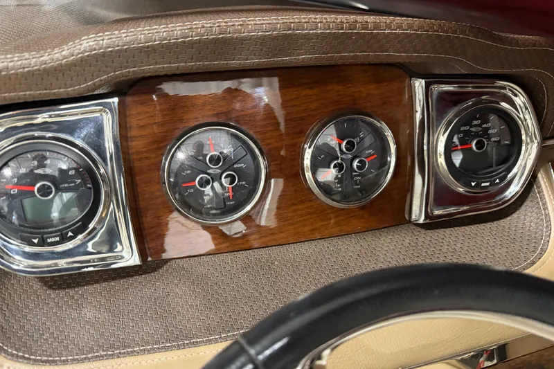 Slide: The Image of Dashboard of 2014 Chaparral 257 SSX boat with wood panel and chrome-trimmed gauges. - 14