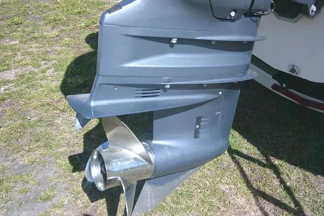 Slide: The Image of 2019 Robalo R207 Dual Console boat propeller and lower unit on grass. - 14