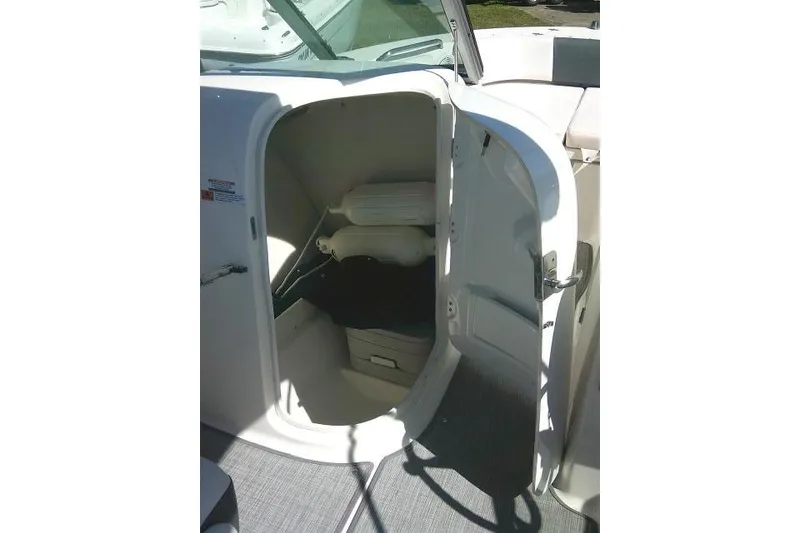 Slide: The Image of 2019 Robalo R207 Dual Console boat storage compartment with open door. - 26