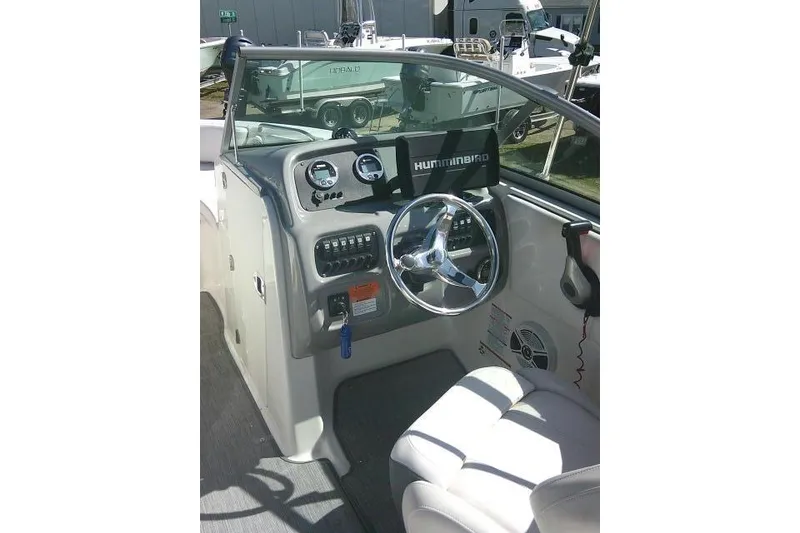 Slide: The Image of 2019 Robalo R207 Dual Console boat cockpit with steering wheel and dashboard controls. - 29