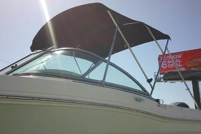 Slide: The Image of 2019 Robalo R207 Dual Console boat with canopy under bright sunlight. - 6