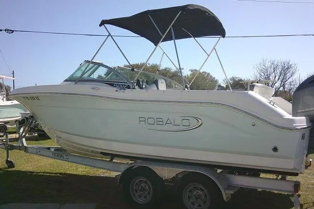 Slide: The Image of 2019 Robalo R207 Dual Console boat on trailer with canopy, parked outdoors. - 9