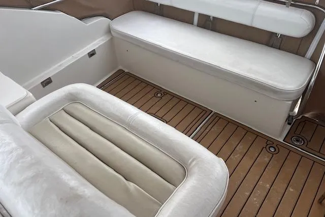 Slide: The Image of Interior seating of 1993 Maxum 2700 SCR boat with white cushions and wooden flooring. - 6