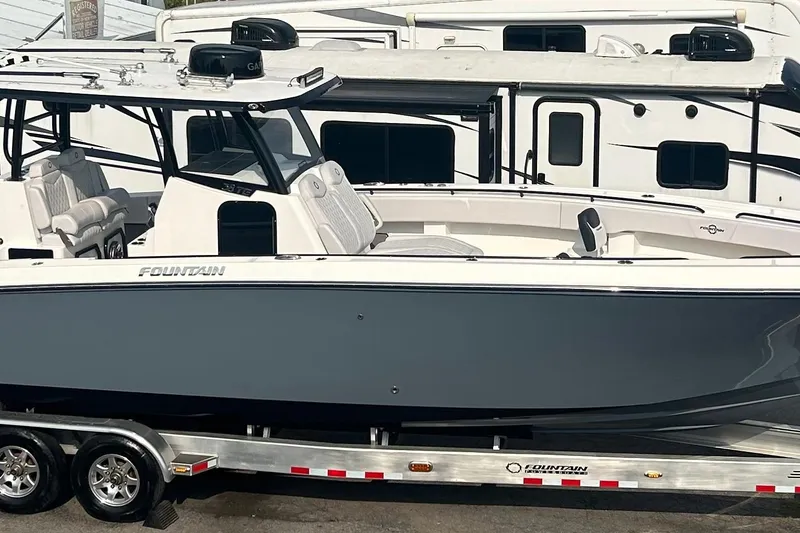 Slide: The Image of 2023 Fountain 38 CC Tournament Edition boat on trailer, parked near RVs. - 2