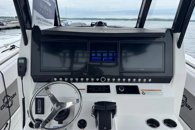 Slide: The Image of 2023 Fountain 38 CC Tournament Edition boat dashboard with dual screens and steering wheel. - 26