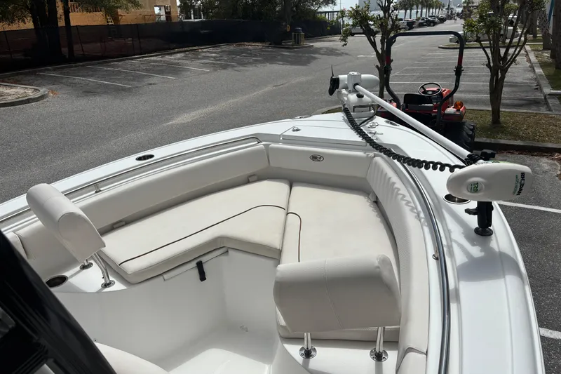 Slide: The Image of 2021 Sea Hunt Ultra 219 boat with cushioned seating and trolling motor in a parking lot. - 10