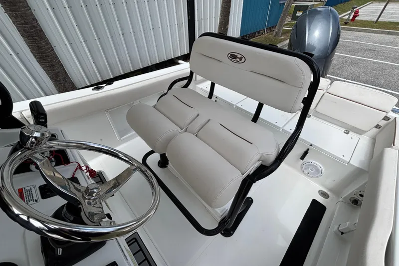 Slide: The Image of 2021 Sea Hunt Ultra 219 boat interior with steering wheel and cushioned seating. - 15