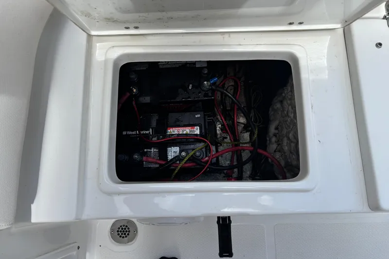 Slide: The Image of Battery compartment of a 2021 Sea Hunt Ultra 219 boat, featuring wiring and connections. - 21