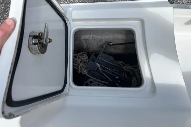 Slide: The Image of Open storage compartment on 2021 Sea Hunt Ultra 219 boat, containing ropes and anchor. - 23