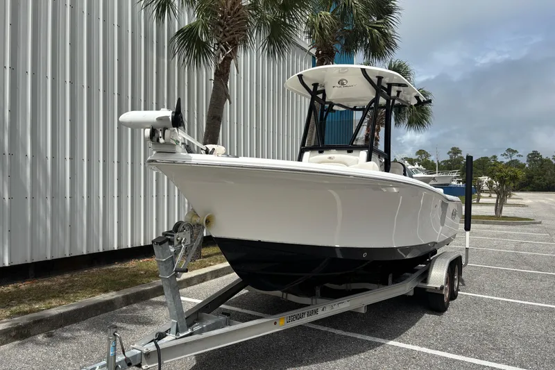 Slide: The Image of 2021 Sea Hunt Ultra 219 boat on trailer near palm trees. - 5