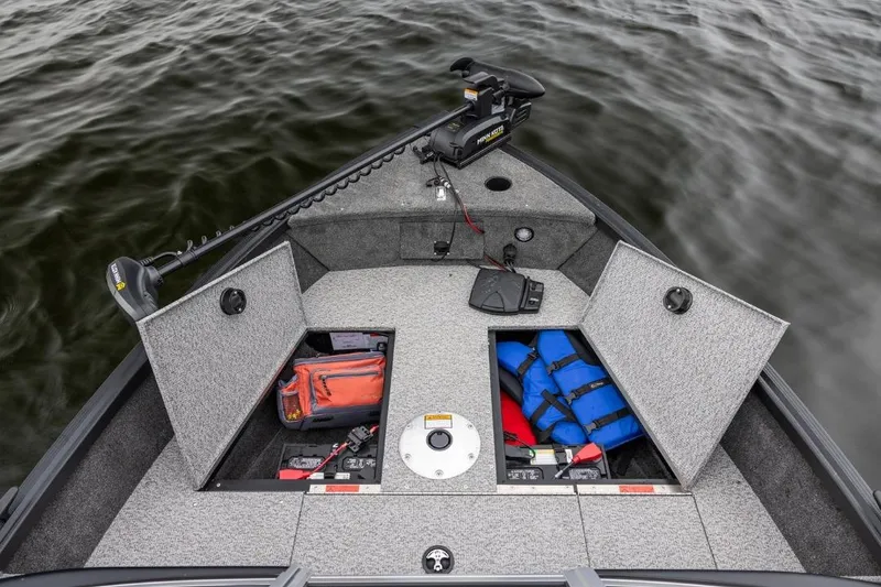 Slide: The Image of 2026 Alumacraft Classic 165 Tiller boat with open storage compartments and safety gear on water. - 15