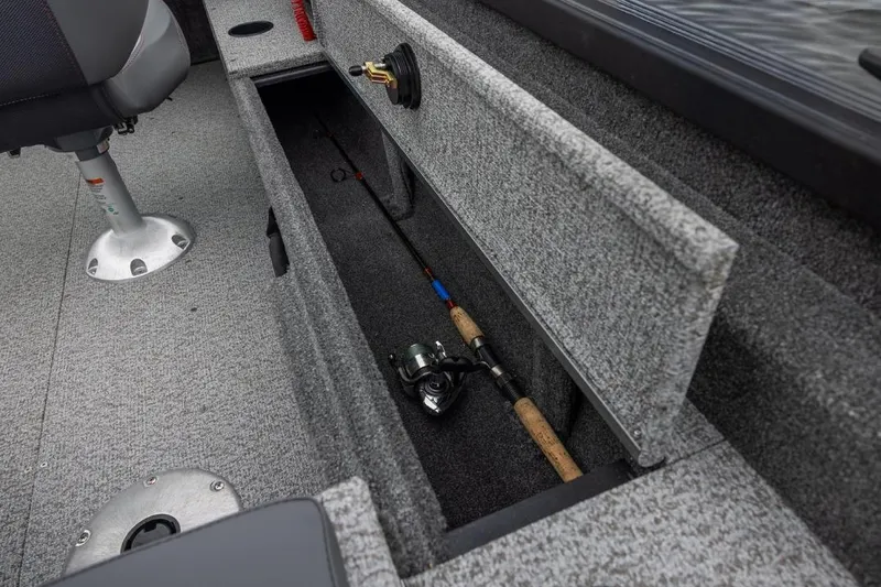 Slide: The Image of 2026 Alumacraft Classic 165 Tiller boat interior with fishing rod storage compartment. - 4