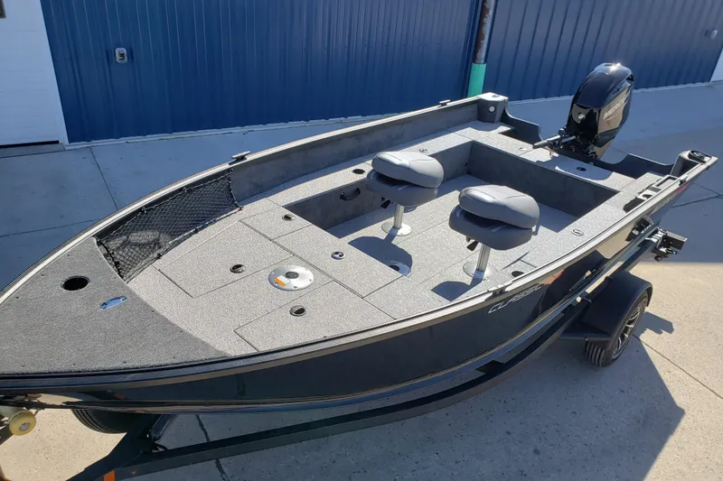 Slide: The Image of 2026 Alumacraft Classic 165 Tiller boat with dual seats and motor, parked outdoors. - 7