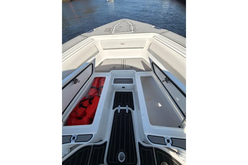 Slide: The Image of 2021 Sea Hunt Gamefish 25 boat deck with open storage compartments and life jackets. - 11