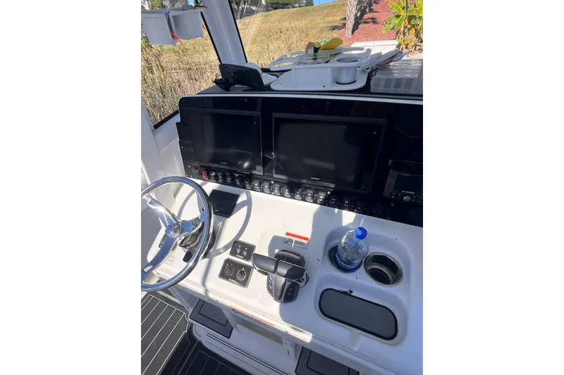 Slide: The Image of 2021 Sea Hunt Gamefish 25 helm with dual displays and steering wheel. - 13