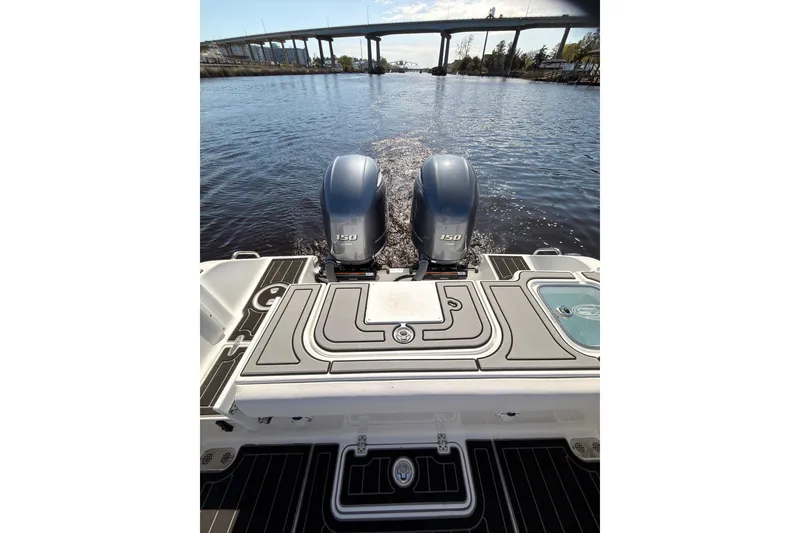 Slide: The Image of 2021 Sea Hunt Gamefish 25 boat with dual 150 horsepower engines on a calm river. - 16