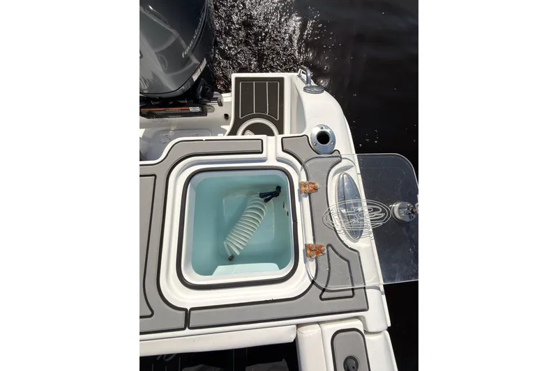 Slide: The Image of 2021 Sea Hunt Gamefish 25 boat deck with livewell and motor, on water. - 18