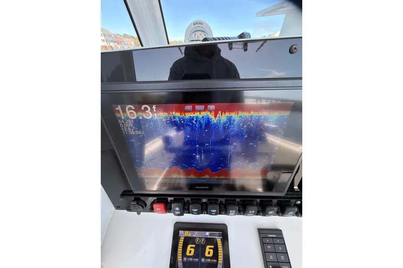 Slide: The Image of 2021 Sea Hunt Gamefish 25 dashboard with Garmin fishfinder display and controls. - 22