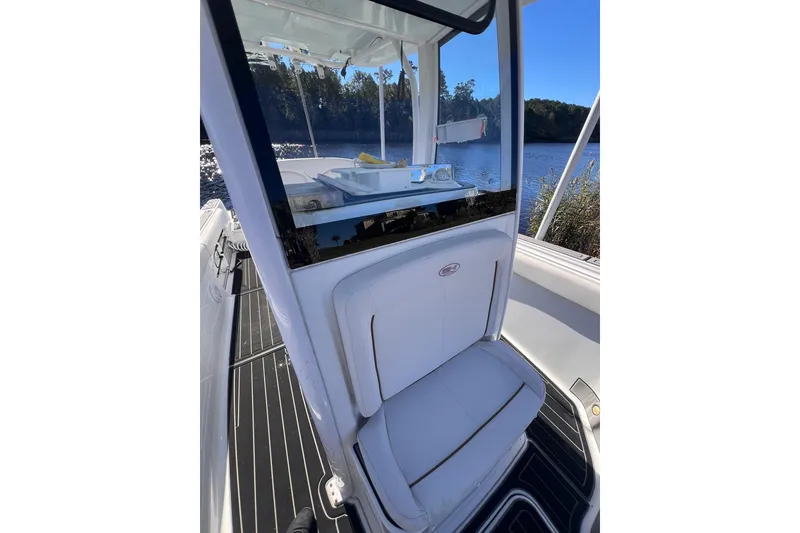 Slide: The Image of 2021 Sea Hunt Gamefish 25 boat interior with seating, near a scenic waterway. - 8