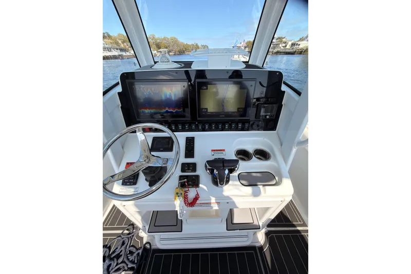 Slide: The Image of 2021 Sea Hunt Gamefish 25 helm with navigation screens and steering wheel. - 9
